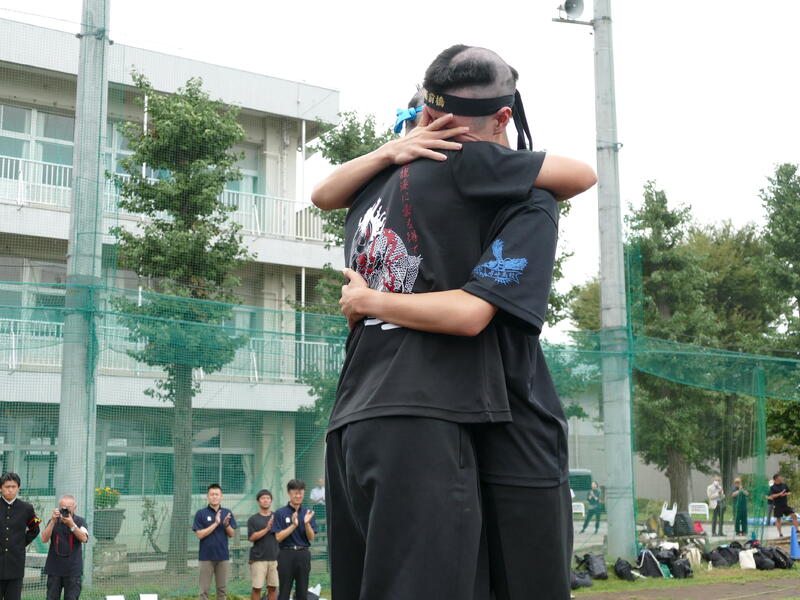 称えあう両校実行委員長